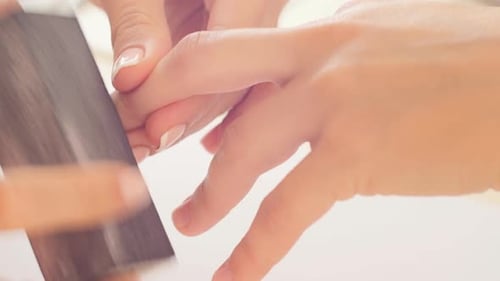 Manicurist Filing Nails in Beauty Salon Close Up