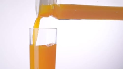 Fresh Orange Juice Pouring into Glass