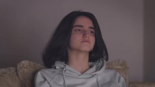 Girl with black hair watching a movie at night alone