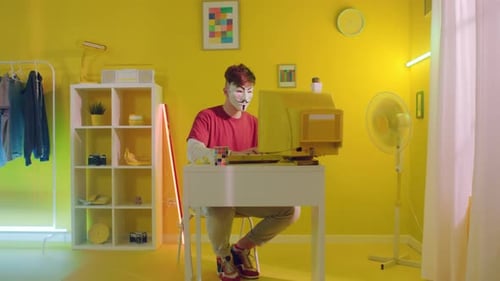 Masked Hacker Using Vintage Computer in Yellow Room