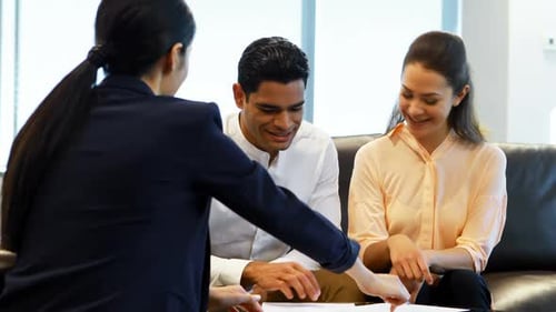 Businesswoman Meeting with Couple in Bright Office