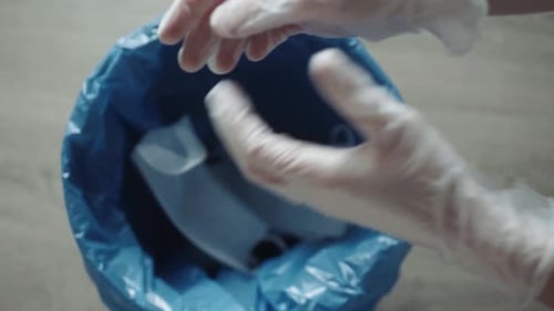 Discarding Gloves and Medical Mask Into Trash Can