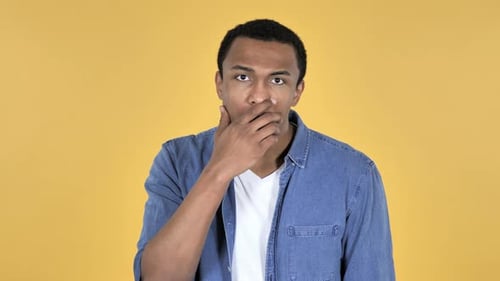 Man Reacts in Shock Against Yellow Background