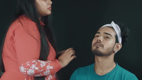 Woman Applying Makeup to a Young Adult