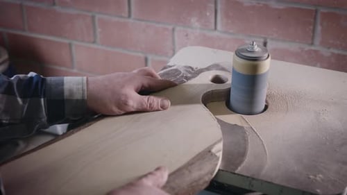 Man Shaping Wood with High-Speed Grinder