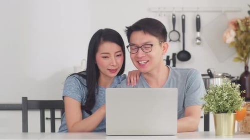 Couple Smiling Using Laptop at Home Together