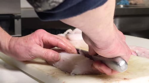 Close up of white cook's hands cleaning fish