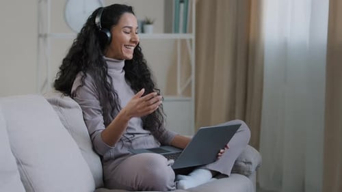 Woman Chatting on Laptop Wearing Headphones Indoors