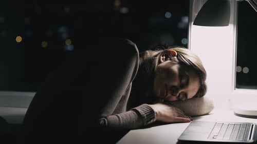 Woman Sleeping at Desk in Front of Laptop