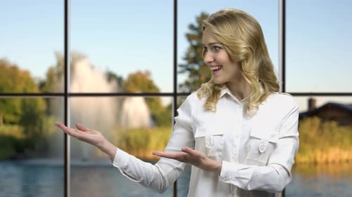 Confident Woman Presenting in Front of Window
