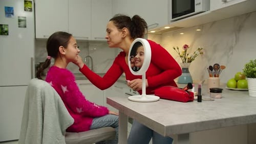Fröhliche Mutter, die zu Hause Mascara auf Preteen Girl aufträgt