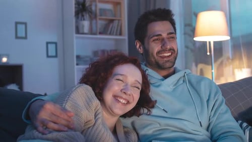 Couple Laughing Watching TV at Night