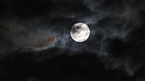 Dramatic Full Moon Amidst Dark Night Clouds
