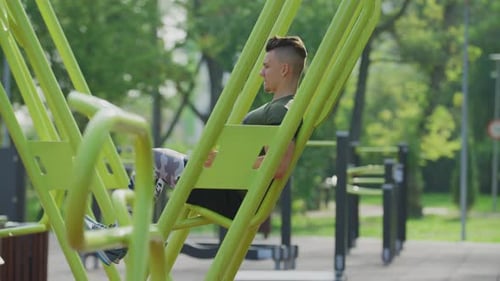 Young man exercising at an outdoor gym