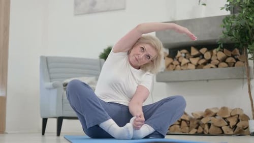 Senior Woman Stretching on Yoga Mat at Home