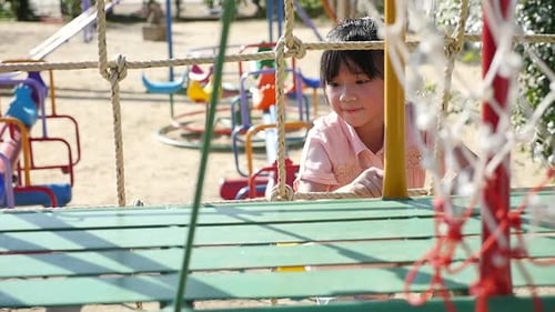 Cute Asian Child Climbing Rope At The Playground