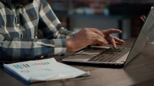 Adult Typing on a Laptop in an Office