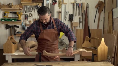 Woodworker Crafting Wooden Piece in Workshop