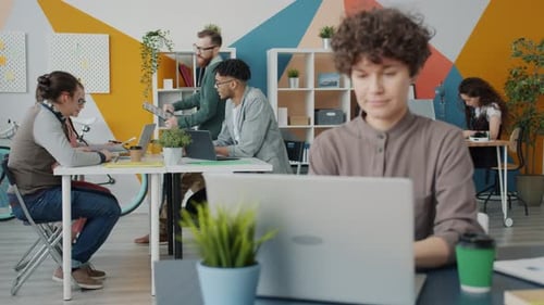 Cheerful Office Worker Riding Bike in Workplace Giving Paper To Coworker Talking