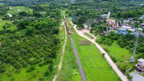Aerial View of Train Traveling Through Green Countryside