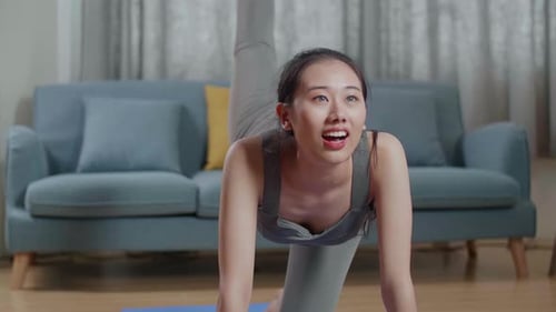 Asian Athletic Female Exercising, Stretching And Practicing Yoga At Home With Online Coach