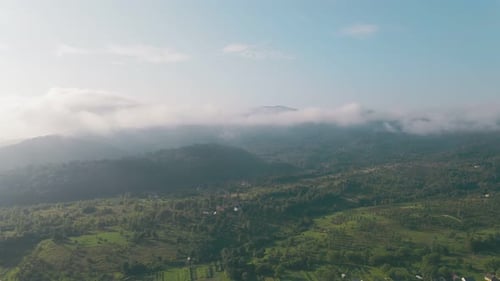 Flight Over the Mountains in the Morning. The Mountain Range on the Horizon Is Covered with Morning