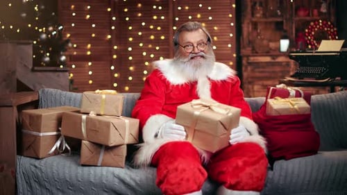 Cheerful Male Santa Claus Posing with Wrapped Christmas Gift Boxes