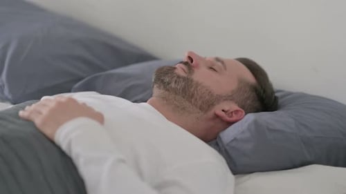 Homme se réveillant d'un cauchemar au lit