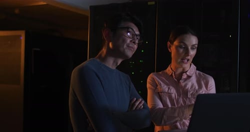 Verschiedene weibliche und männliche IT-Techniker verwenden Laptop-Checking-Computerserver