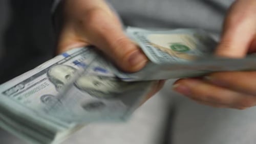 Counting Stack of United States One Hundred Dollar Bills