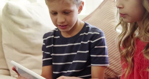 Children Use Tablet on Couch Indoors