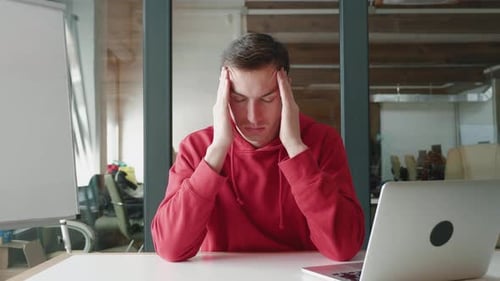 Frustrated Man With Headache in Office Setting