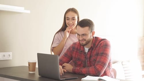 Young Couple Collaborating on Laptop at Home