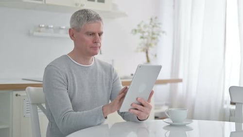 Cheerful Senior Old Man Using Tablet at Home