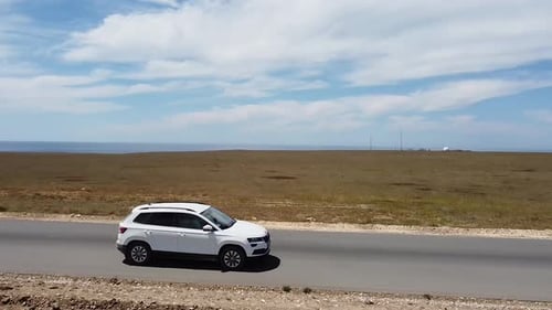 Empruntez une longue route droite à travers la steppe. La voiture part par une belle journée d'été.