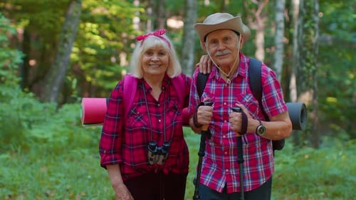 Senior Couple Hiking Together Through Green Forest