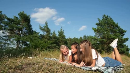 Happy Children Lying on the Grass Outdoors in the Woods