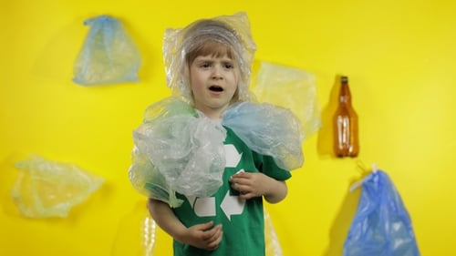 Niña activista se libera de paquetes de plástico en el cuello y la cabeza. Contaminación plástica. Salva la ecología