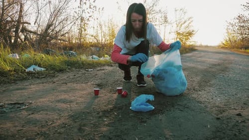 Cuida la naturaleza. Una niña voluntaria recoge basura en la bolsa de basura. Concepto de planeta sin basura.
Naturaleza
