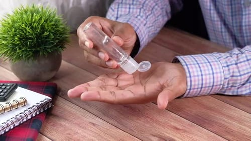 Close Up of Young Man Hand Using Sanitizer Gel for Preventing Virus