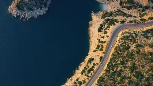 Blue Sea Rocky Coast and Asphalt Mountain Road