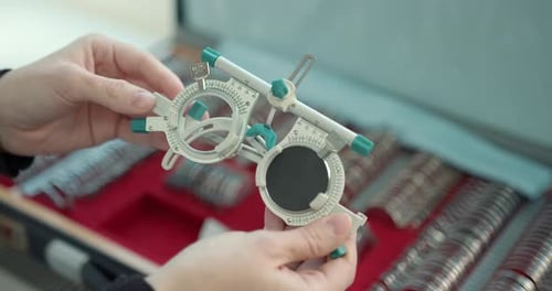 Nahaufnahme von Optiker wählt Objektive im Geschäft für moderne Lichtoptik