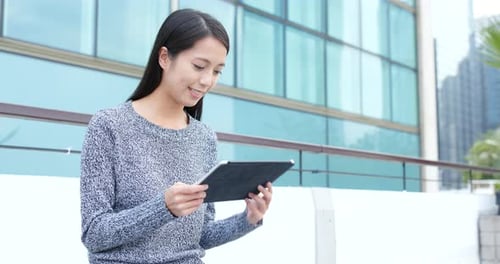 Young woman use of digital tablet in city