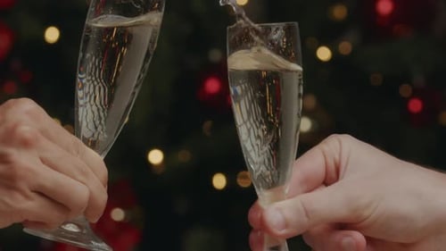 Clinking Champagne Glasses in Front of Christmas Tree