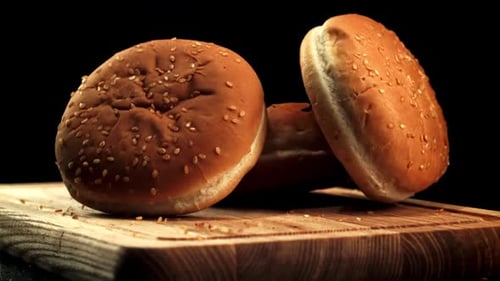 Hamburger Buns Falling on Cutting Board in Slow Motion