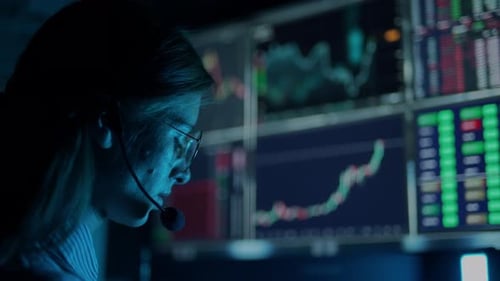 Trader is Working with Multiple Computer Screens with Charts and Data Analysis and Stock Broker