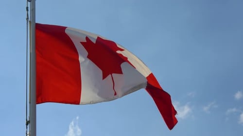 Canadian Flag Waving Against a Blue Sky