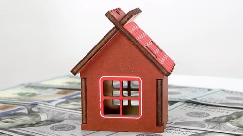 Model of Small Familly House Standing on Background of Dollars Banknotes and Rotate Slowly