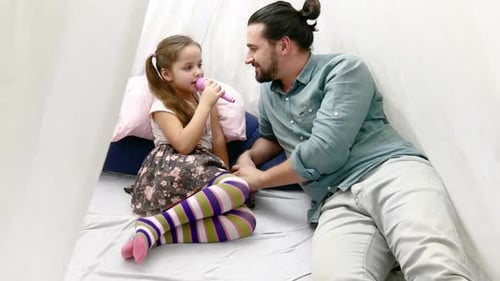 Father and Child Singing with Toy Microphone