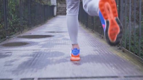 Male Runner in Colorful Sport Shoes Running on Hanging Bridge, Close View